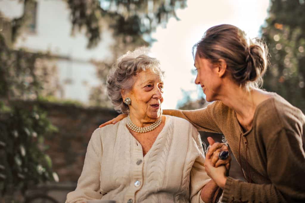 Angehörige im Gespräch mit einer pflegebedürftigen Seniorin