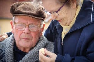 Eine Seniorin reicht einem Senior etwas zu essen.