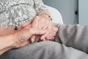 Die Hand einer Seniorin wird gehalten.