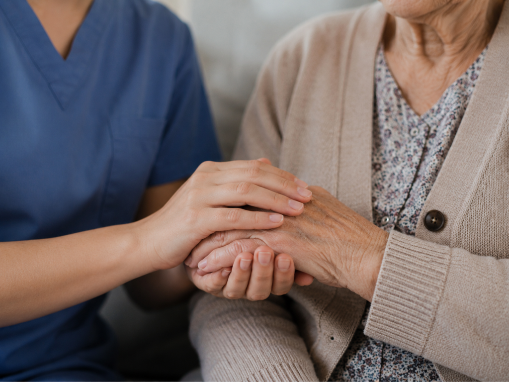 Nahaufnahme einer Pflegekraft, die die Hand einer älteren Frau hält